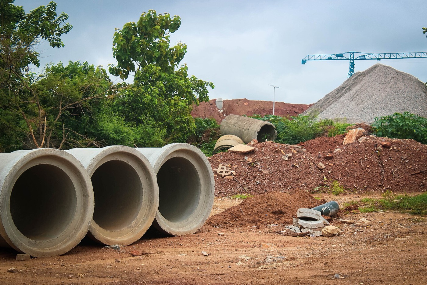 Crane and concrete pipe at a construction site